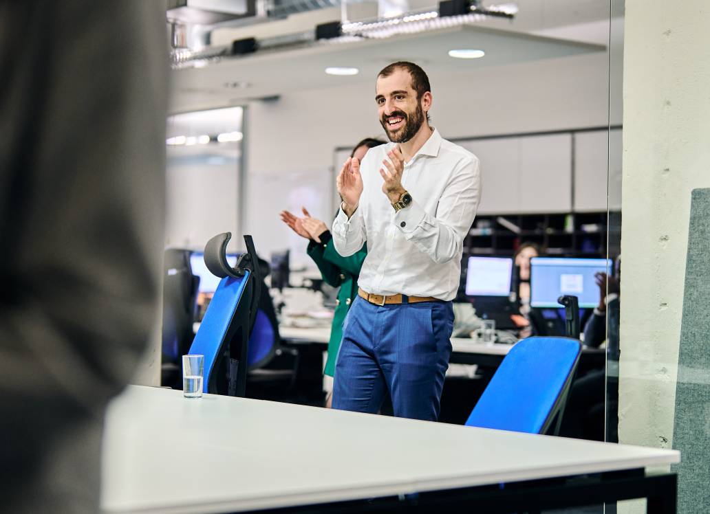 Man clapping in an office environment.